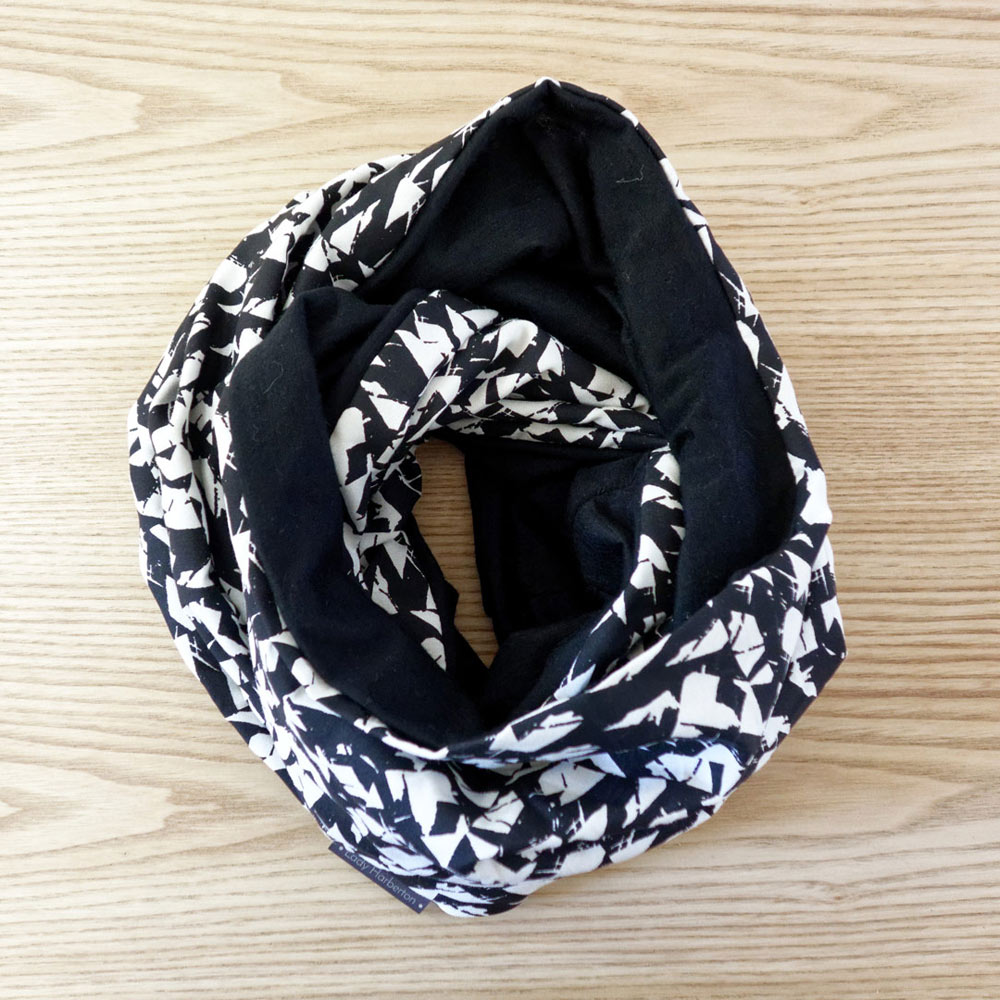 Shop By Country The snood is similar to an infinity scarf, which is a looped scarf that sits around the neck. They differ in that the snood sits higher on the neck and can often act like a hood. So while an infinity scarf could technically act like a snood, and a snood like an infinity scarf, there are some subtle differences.